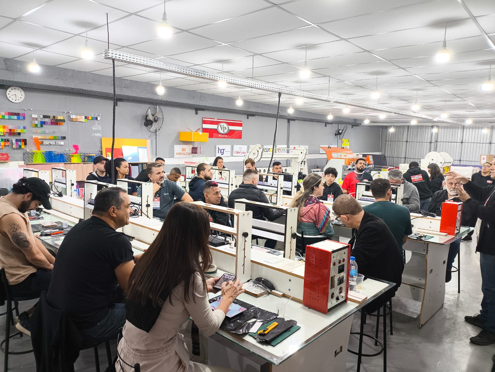 Participantes do workshop trabalhando em dobradeiras VP durante a prática em bancada